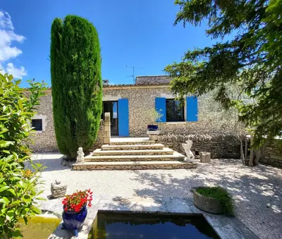 a house with blue doors and a large tree at 