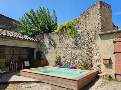 a swimming pool in front of a stone building at Maison provençale, piscine, calme et Lubéron in Le Thor