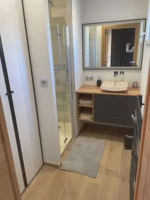 a bathroom with a shower and a sink and a mirror at logement avec jacuzzi in Joucas