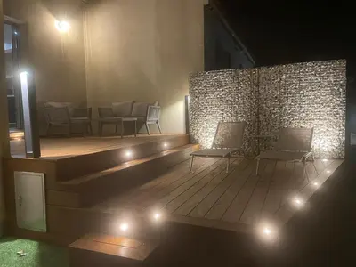 a room with chairs and lights on a wooden floor at logement avec jacuzzi in Joucas