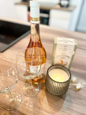 a bottle of wine and glasses on a wooden table at Rotonde, 2 chambres, Air conditionné in Aix-en-Provence