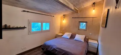 a small bedroom with a bed and two windows at Villa Provençale Harmonie 8 Guest poolhouse in Lambesc