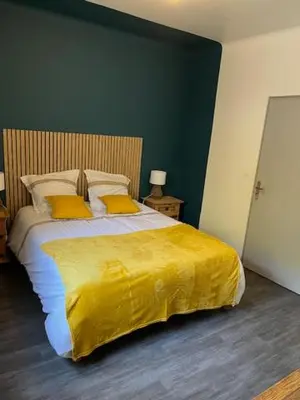 a bedroom with a large bed with a yellow blanket at Villa les trois pins in Venelles
