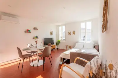 a living room with a bed and a table and chairs at Le Saint Sauveur - Centre Ville - Calme - Lumineux in Aix-en-Provence