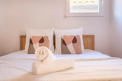 a bed with a towel on it with pillows at Le Saint Sauveur - Centre Ville - Calme - Lumineux in Aix-en-Provence