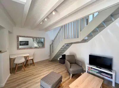 a living room with a staircase and a television at Terrasse à Aix en Provence centre historique in Aix-en-Provence