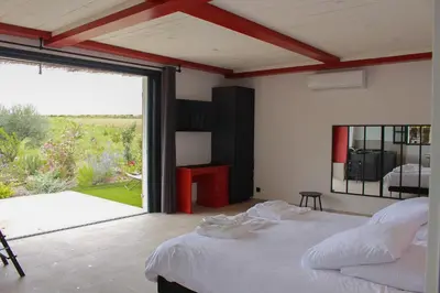 a bedroom with a large bed and a large window at Ferme de restantier, love room in La Tour-dʼAigues