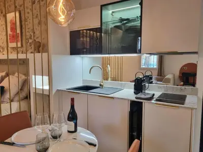 a kitchen with a table with wine glasses on it at 25 rue Celony - Le Vendome - Jacuzzi - VideoProjecteur in Aix-en-Provence