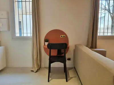a chair in a room with a table and a couch at 25 rue Celony - Le Vendome - Jacuzzi - VideoProjecteur in Aix-en-Provence