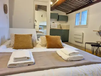 a large bed with towels on top of it at Studio lumineux clim - centre ville in Aix-en-Provence