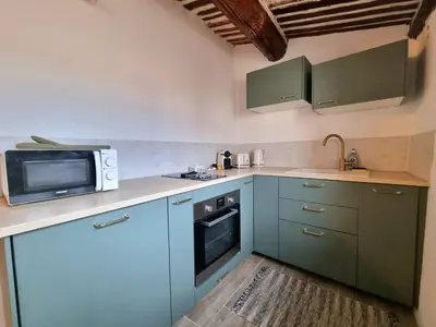 a kitchen with blue cabinets and a microwave at Studio lumineux clim - centre ville in Aix-en-Provence