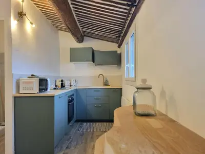 a kitchen with blue cabinets and a wooden table at Studio lumineux clim - centre ville in Aix-en-Provence