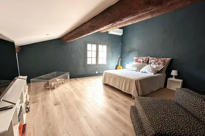 a bedroom with a bed and a green wall at Maison Ange & Lice in Pernes-les-Fontaines