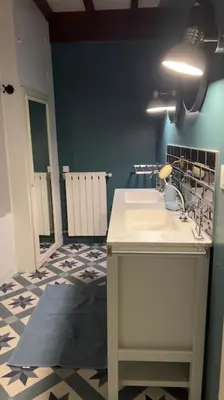 a bathroom with a sink and a blue wall at Maison Ange & Lice in Pernes-les-Fontaines