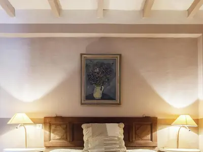 a bedroom with a vase of flowers on the wall at Charming Cottage in Oppède amidst Vineyards in Maubec