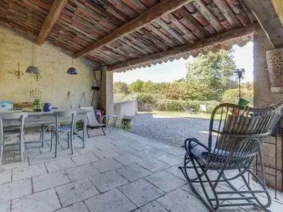 a patio with a table and chairs on a patio at Charming Cottage in Oppède amidst Vineyards in Maubec