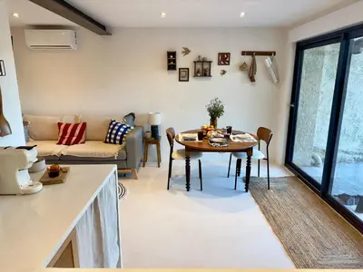 a living room with a table and a couch at Logement de Charme vue Luberon - Rez-de-chaussée de maison, Jardin & Piscine in La Tour-dʼAigues