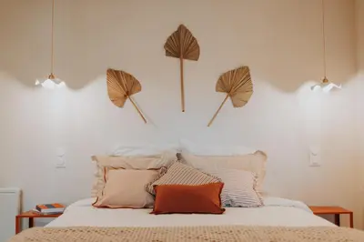 a bedroom with a bed with three umbrellas on the wall at Logement de Charme vue Luberon - Rez-de-chaussée de maison, Jardin & Piscine in La Tour-dʼAigues
