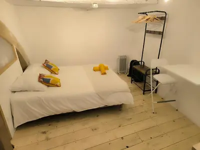 a bedroom with a bed with yellow pillows on it at Les studettes du Beffroi in Cucuron