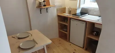 a small kitchen with a table and a sink at Les studettes du Beffroi in Cucuron