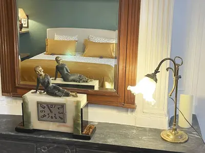 a room with a bed and a clock and a lamp at Appart d exception 2 chambres quartier Mazarin in Aix-en-Provence