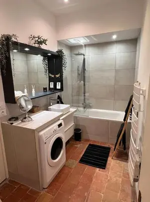 a bathroom with a washing machine and a bath tub at Appart d exception 2 chambres quartier Mazarin in Aix-en-Provence