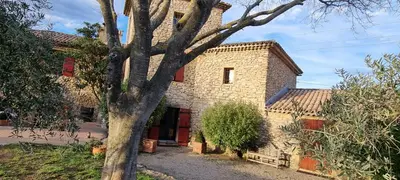 a stone house with a tree in front of it at Moulin AURELIA - chambre La Coloniale in Pélissanne