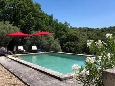 a swimming pool with two chairs and an umbrella at Holiday Home in Lacoste with Pool in Lacoste