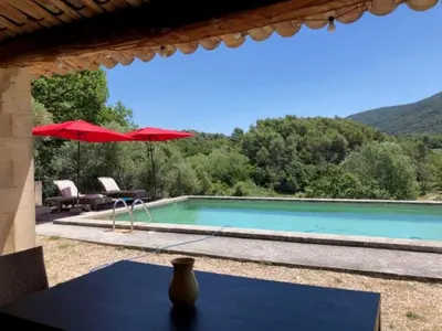 a pool with a table and a red umbrella at Holiday Home in Lacoste with Pool in Lacoste