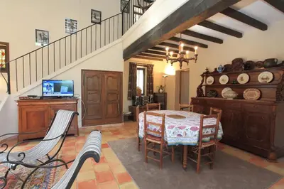 a dining room with a table and chairs and a staircase at Villa La Familliale, piscine avec vue imprenable sur Gordes in Gordes