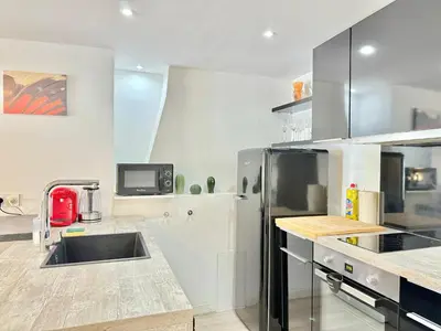 a kitchen with a sink and a refrigerator at Appartement chic, hyper centre in Aix-en-Provence