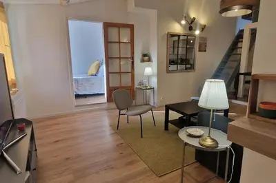 a living room with a table and chairs and a staircase at Cocon ensoleillé centre ville historique, Clim Wifi 4 people in Aix-en-Provence