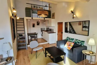 a living room with a blue couch and a kitchen at Cocon ensoleillé centre ville historique, Clim Wifi 4 people in Aix-en-Provence