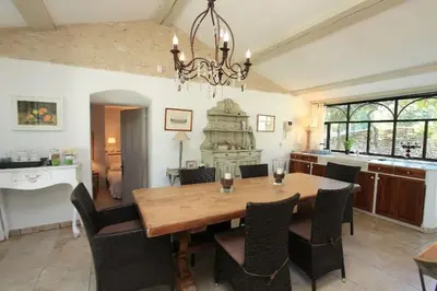 a dining room with a wooden table and chairs at Villa La Raffinée, au coeur des garrigues du Luberon in Gordes
