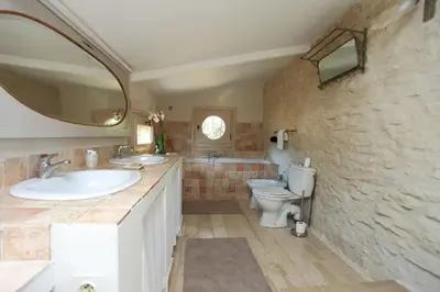 a bathroom with a sink and a toilet and a mirror at Villa La Raffinée, au coeur des garrigues du Luberon in Gordes