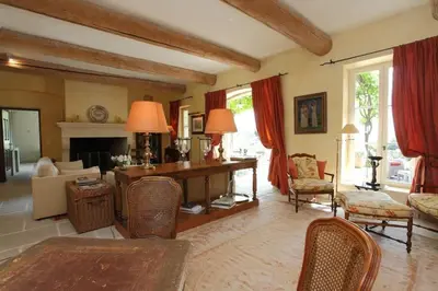 a living room with a fireplace and a table and chairs at Villa l'Écrin, piscine et 3 terrasses in Gordes