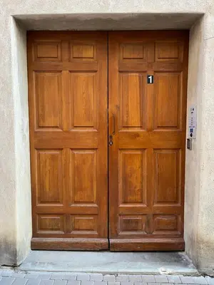 a pair of wooden doors in a building at Appartement 100 m2 au cœur de l'Isle sur la Sorgue in LʼIsle-sur-la-Sorgue