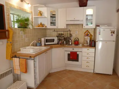 a kitchen with white cabinets and a white refrigerator at La Calvinette in Pernes-les-Fontaines