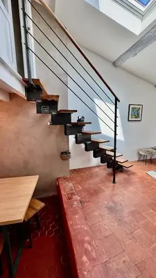 a metal staircase in a room with a table at artist plein centre ville historique in Aix-en-Provence