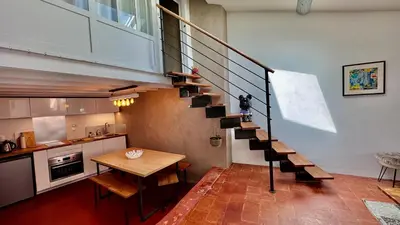 a staircase in a room with a table and a kitchen at artist plein centre ville historique in Aix-en-Provence