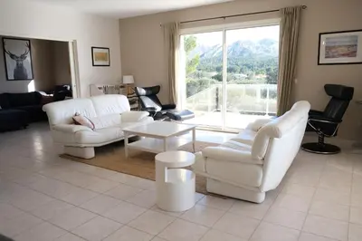 a living room with white furniture and a large window at villa avec piscine aureille alpilles paragi ls1-449 in Aureille