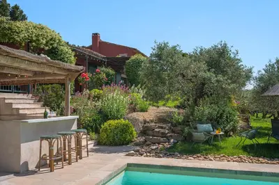 a backyard with a swimming pool and chairs and a house at Le Mas Elaïa, votre havre familial avec piscine privée in Eyragues