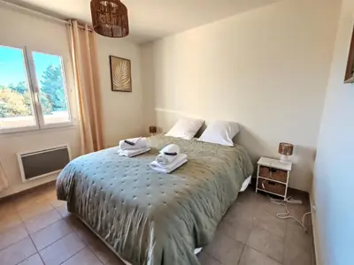 a bedroom with a bed with towels on it at Les deux Oliviers in Roussillon