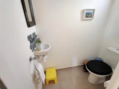 a bathroom with a black toilet and a sink at Les deux Oliviers in Roussillon