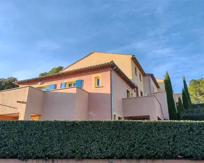 a house with a hedge in front of it at Les deux Oliviers in Roussillon