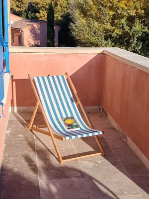 a blue and white chair sitting on a balcony at Les deux Oliviers in Roussillon