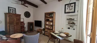 a living room with a table and chairs at Studio cozy avec terrasse en centre ville in LʼIsle-sur-la-Sorgue