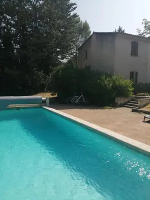 a large blue swimming pool next to a building at #Villa Théo# Grande villa avec piscine in Apt