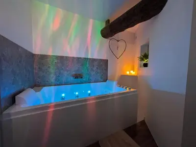 a bathroom with a bath tub with a heart on the wall at La Galatée, Balnéo et Sauna privatifs in Saint-Saturnin-lès-Avignon