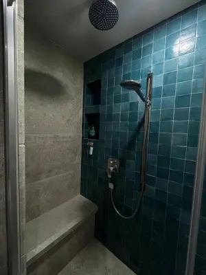 a bathroom with a shower with blue tiles at Maisonnette climatisée in Aix-en-Provence